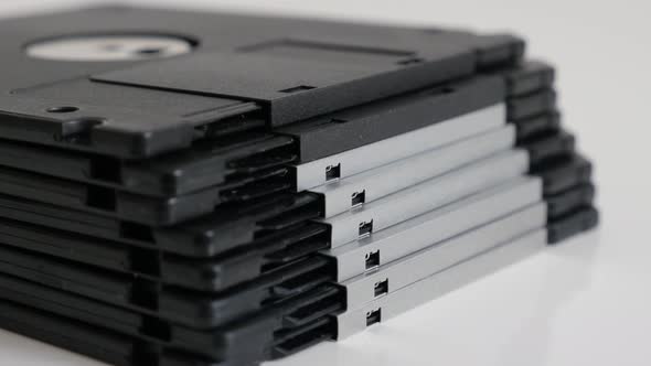 Floppy disc classic magnetic storage media on white 4K 2160p 30fps UHD tilting footage - Old black d
