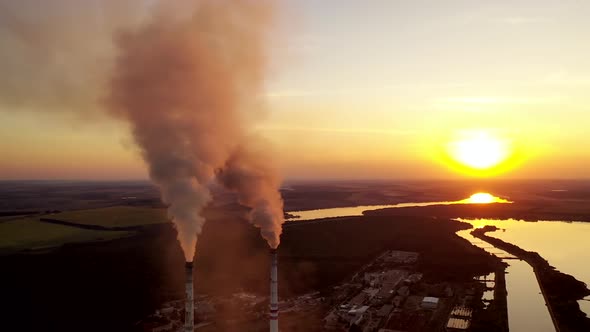Air polluting factory chimneys. Powered power station plumes from chimneys with sun behind