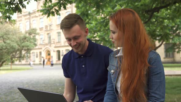 Couple of Students Discusses Something on Laptop on Campus