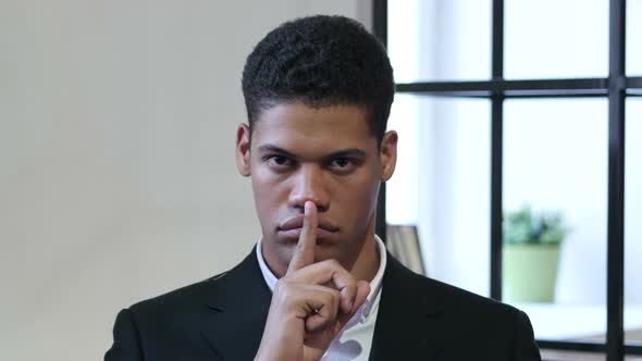 Gesture of Silence by Black Businessman, Finger on Lips