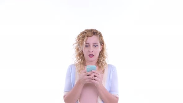 Happy Beautiful Blonde Woman Using Phone and Looking Surprised