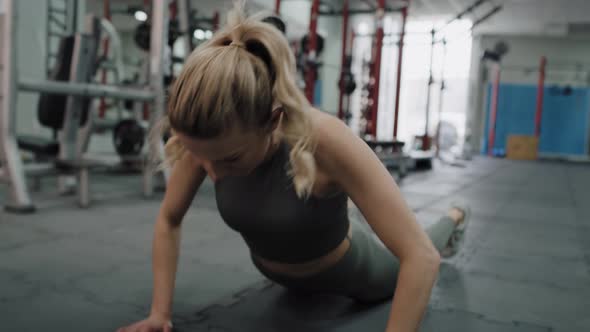 Woman exercising dynamic jumps on floor in the gym. Shot with RED helium camera in 8K.