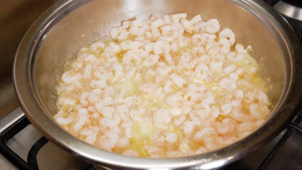 Fresh small shrimps cooking on butter sauce in silver hot pot