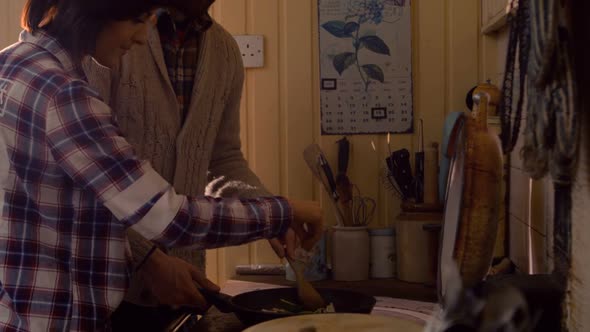 Couple cooking food together in kitchen