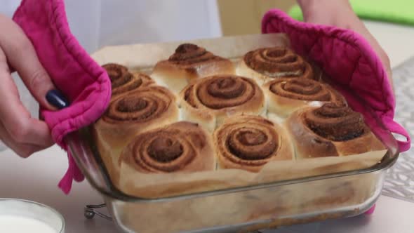 A Woman Demonstrates Cooked Cinnabons.