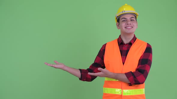 Happy Young Multi Ethnic Man Construction Worker Showing Something