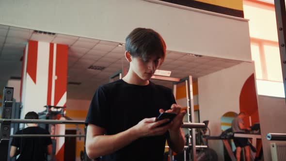 Man in the Gym Young Man Trains on a Elliptical Bike Simulator Aerobic Exercise and Endurance
