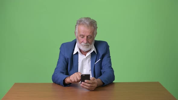 Handsome Senior Bearded Businessman Against Green Background