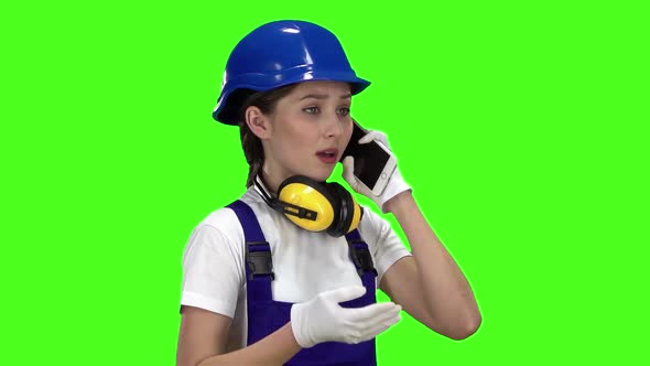 Engeneer Girl in a Helmet Standing and Talking on the Phone . Green Screen. Slow Motion alt