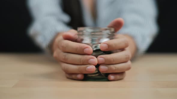 Money saving and economy Concept, Women hand hold a clear glass jar