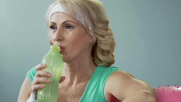 Lady of Senior Age Leaning on Fitness Ball, Drinking Water and Exhaling, Results