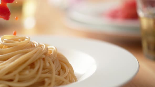 Camera follows putting fresh tomato sauce over spaghetti in plate. Slow Motion.