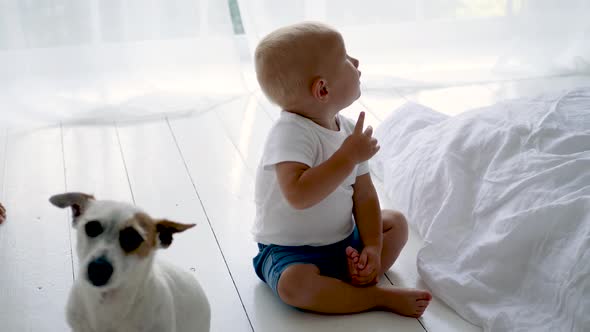 Child in a White T-shirt Sitting on the Floor in a White Room