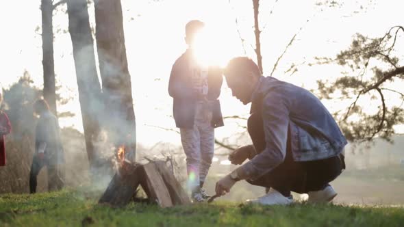 Happy family concept. Young mother and father kissing their daughter in the park.