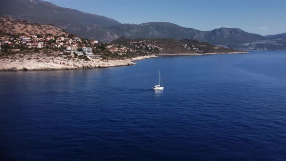 Landscape of Yacht Swimming in the Sea Next to the Coastline and Ancient Mountain City Kas in Turkey