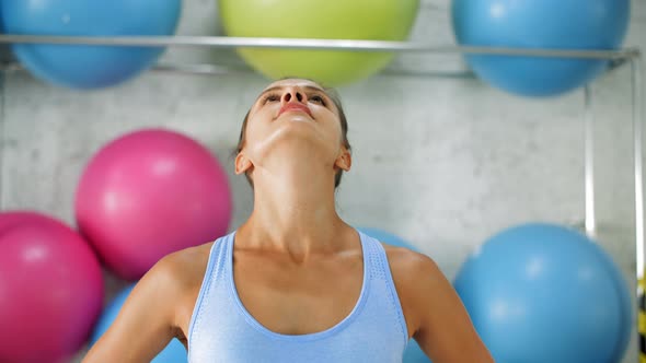 Smiling Sporty Young Woman Tilting Head During Fitness Training