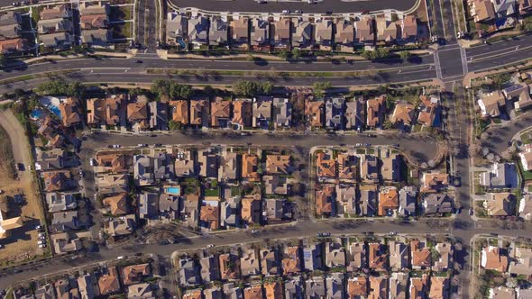 Aerial view flying above rows of new housing real estate development rooftops in Central valley of C