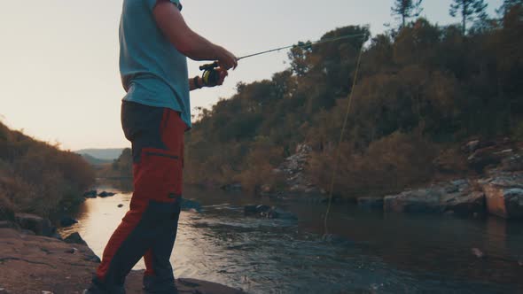 Man Fly Fishing on the River at Sunset