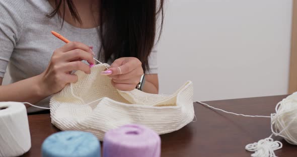 Woman knitter making fabric from thread