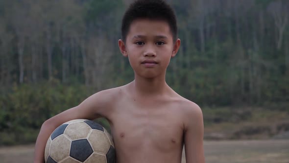 Rural Boy Holding Ball And Looking At Camera alt