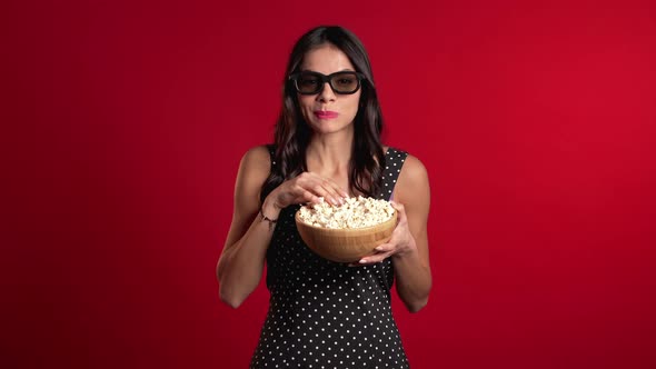 Young Hispanic Woman in 3d Glasses Watching Comedy Movie, Eating Popcorn on Red