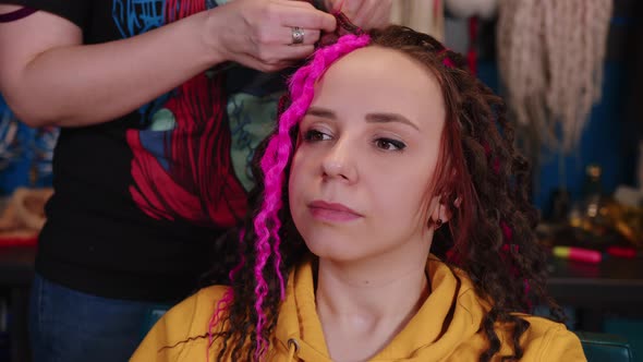 Unrecognizable Person Makes Curly Hairstyle for Young Woman in Salon