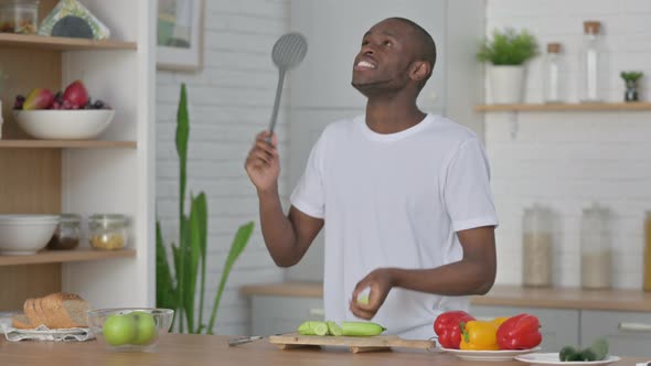 Healthy African Man Dancing While Cooking in Kitchen