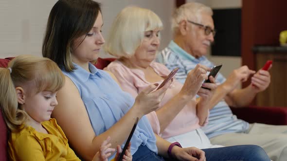 Addicted To Gadgets Family Using Mobile Phone, Tablet, Laptop Ignoring Each Other at Home