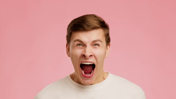 Emotional Guy Shouting Looking At Camera Standing Over Pink Background