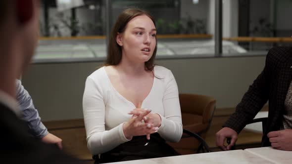 Girl office employee of the financial department tells her colleagues about work