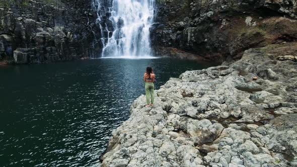 Aerial View of Beautiful Girl at the Waterfall on the Island of Hawaii