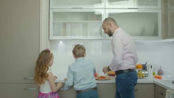 Smiling Father Making Breakfast in Kitchen