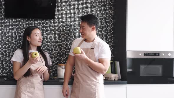 Portrait of Happy Young Asian Couple Cooking Together in the Kitchen at Home