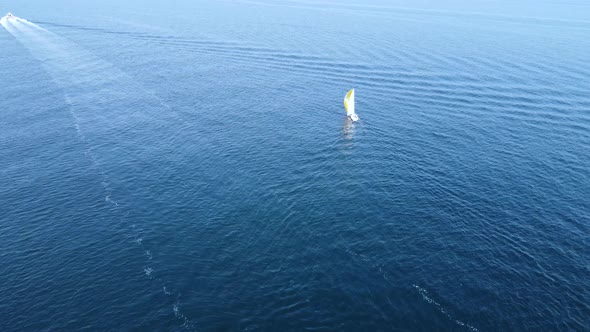 A sailing boat sails into the open sea.