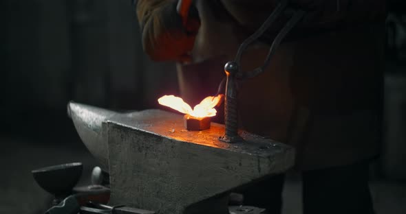 Blacksmith Forges the Red Hot Decorative Metal Product with Hammer on the Anvil Decorative Forging
