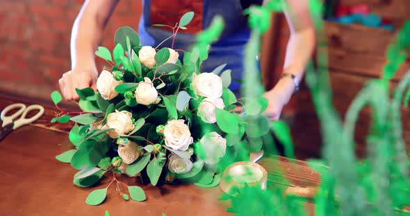 Florist Packs a Rose  Girl Composes Flowers in a Bouquet  Flower Shop