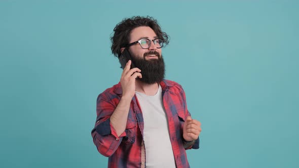 Portrait of Happy Brunette Bearded Man Having a Pleasant Mobile Conversation.