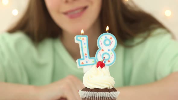 Bautiful Caucasian Girl Blowing 18 Candles on Cake