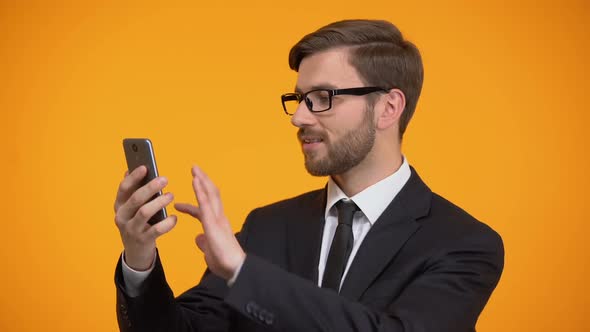 Male Scrolling Smartphone and Smiling at Camera, Useful Business Application