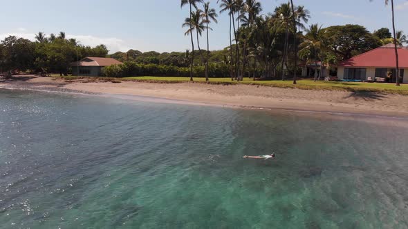 A swimmer snorkels in the clear turquoise water off of Olowalu beach in Maui, Hawaii.