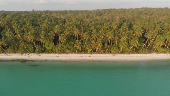 Aerial: uncontaminated white sand beach sunset at Kei Islands Maluku Indonesia