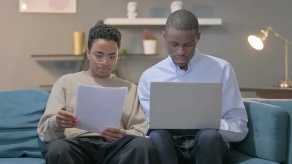 Couple with Laptop Having Success While Reading Documents