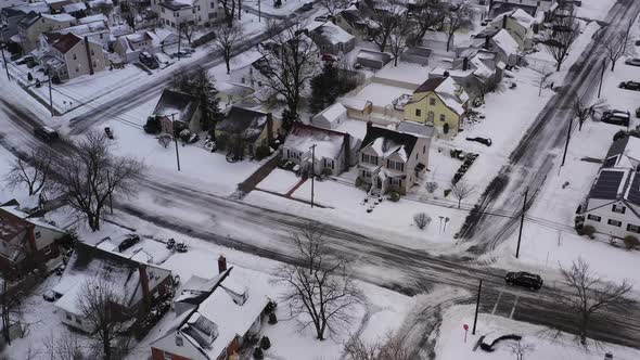 an aerial view over a suburban neighborhood in the morning, after a snow storm. The drone camera pan