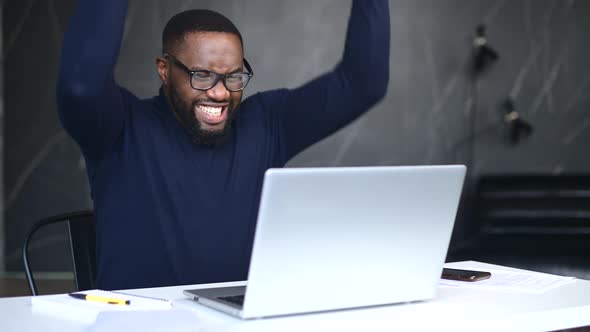 AfricanAmerican Male Employee Using Laptop Indoor