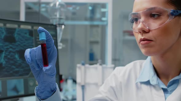 Close Up of Scientist Analyzing Lab Vacutainer with Fluid