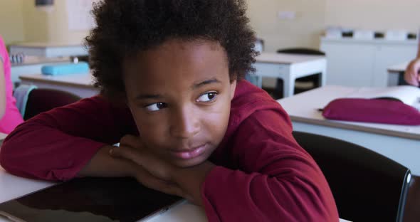 Boy with his head on desk in the class