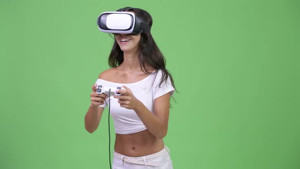 Young Happy Beautiful Multi-ethnic Woman Playing Games While Using Virtual Reality Headset