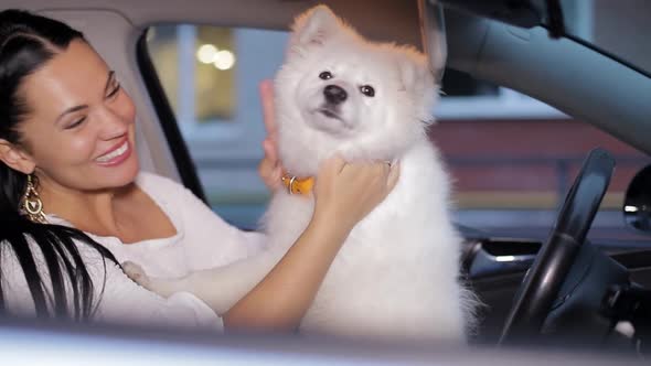 Beautiful Young Woman Travels in the Car with Her