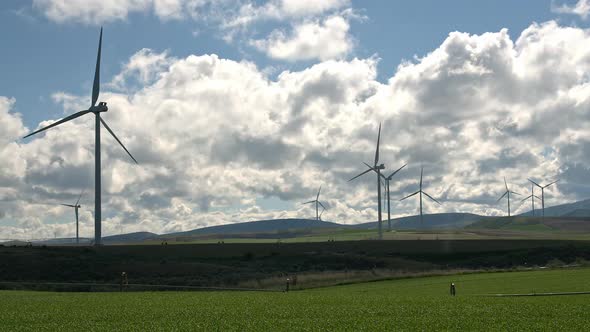 Time lapse of windmills turning through rolling green hills in Idaho