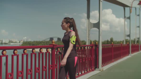 Sporty Female Jogging and Doing Push Ups on Bridge